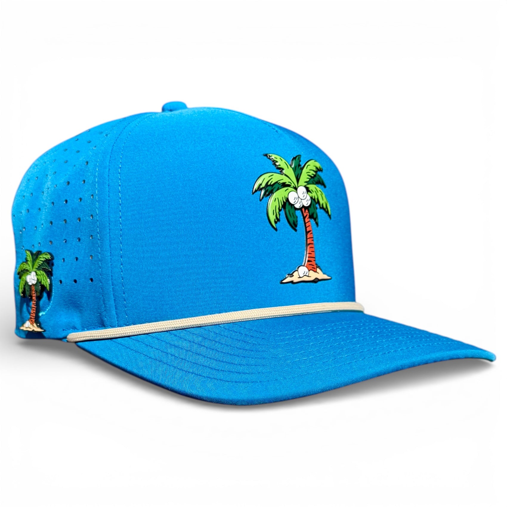 The Fairway Palms Golf Hat is a bright blue adjustable snapback with cartoon palm tree and coconut graphics, beige rope detail, ventilation holes, and a built-in magnetic ball marker holder. Marker is included; one size fits most.