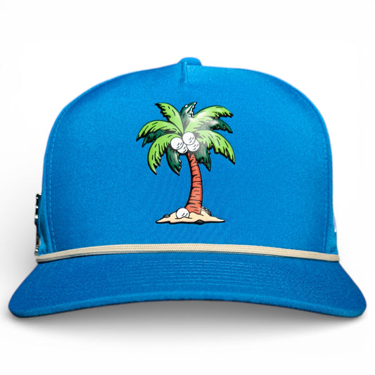 The Fairway Palms Golf Hat is a bright blue snapback with a cartoon palm tree embroidered on the front, a beige band around the crown’s base, and features a built-in magnetic ball marker holder with included marker. Adjustable and one size fits all.