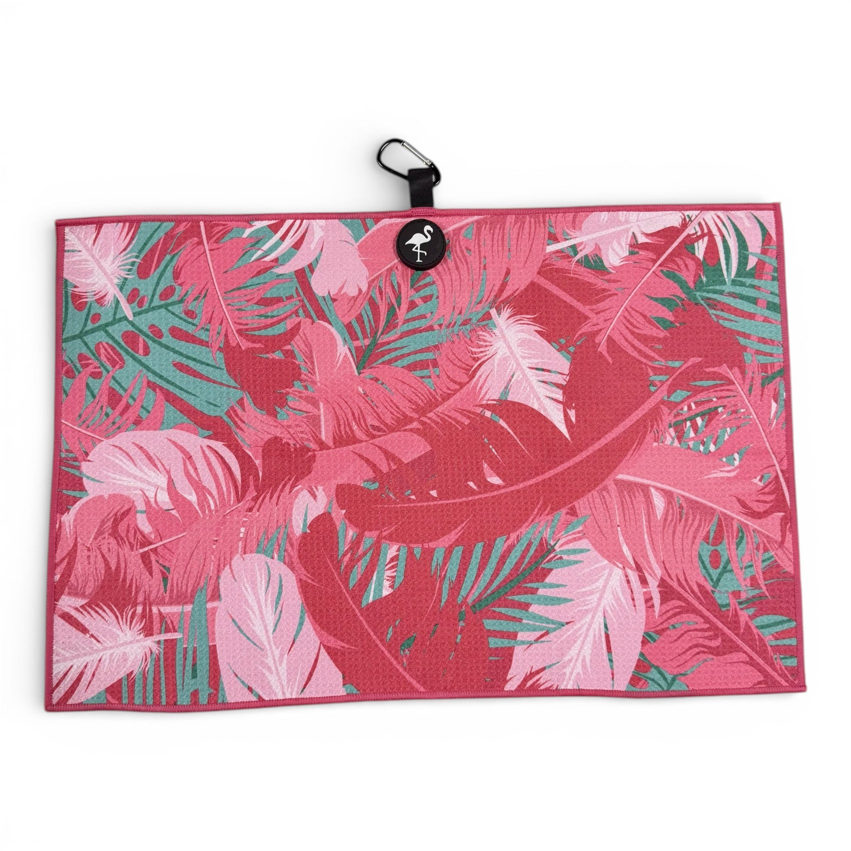 The Pink Tropical Golf Towel (24x16 in) features a pink, red, and green tropical leaf design on premium double-sided microfiber, and includes a heavy-duty magnetic carabiner clip for easy attachment.