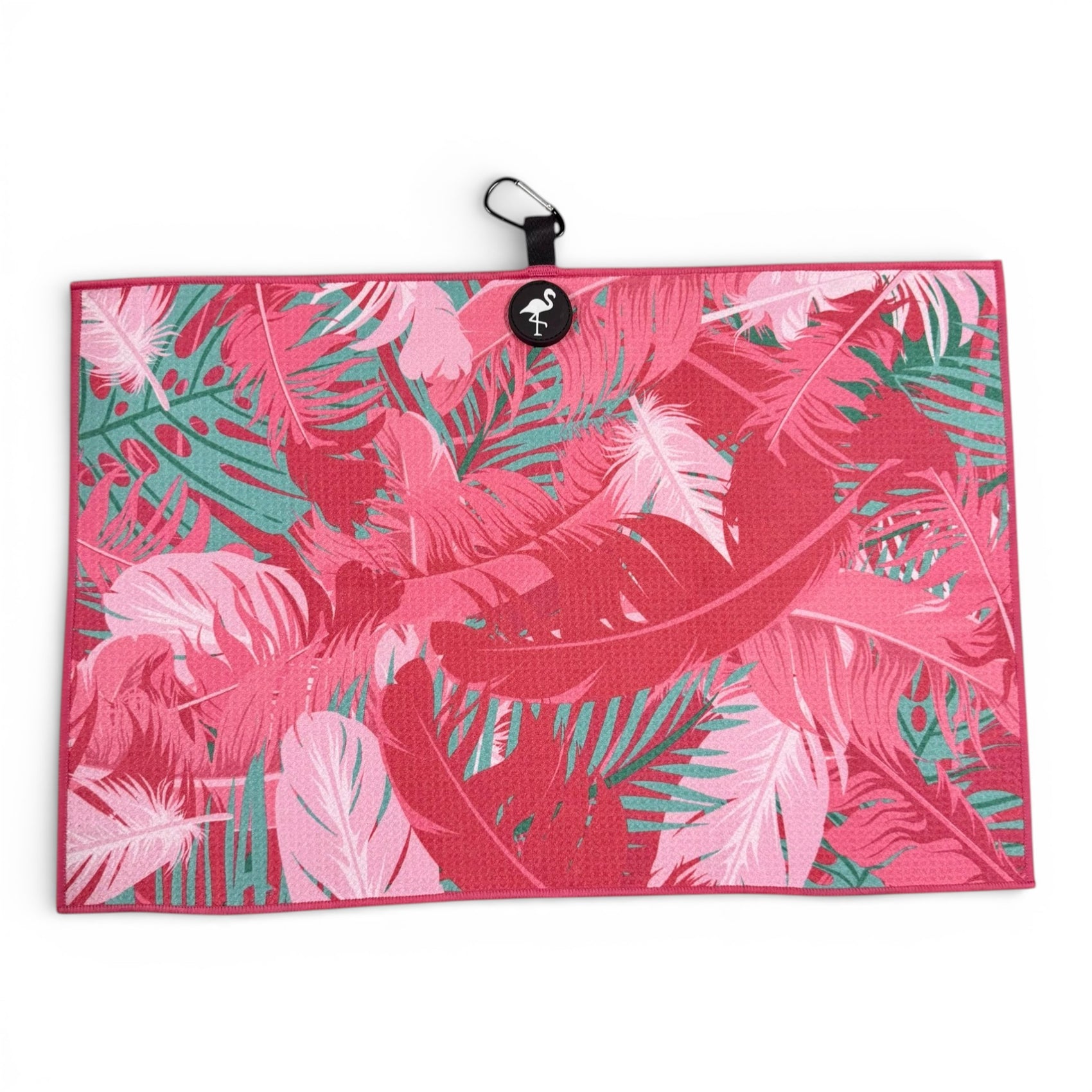 The Pink Tropical Golf Towel features a vibrant pink and green leaf design, double-sided premium microfiber, a heavy-duty magnetic attachment, and a carabiner clip—measuring 24 x 16 in for stylish golfers.