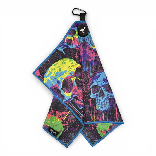 The Neon Skull Golf Towel features vibrant neon skull art on black, blue edges, a heavy-duty magnetic design, carabiner clip, and is crafted from premium double-sided microfiber for durability. Size: 24 x 16 in.