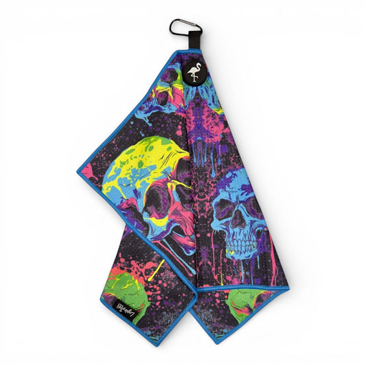 The Neon Skull Golf Towel features vibrant neon skull art on black with blue trim. This 24x16 in double-sided premium microfiber towel includes a heavy-duty magnetic backing and carabiner clip for easy attachment.