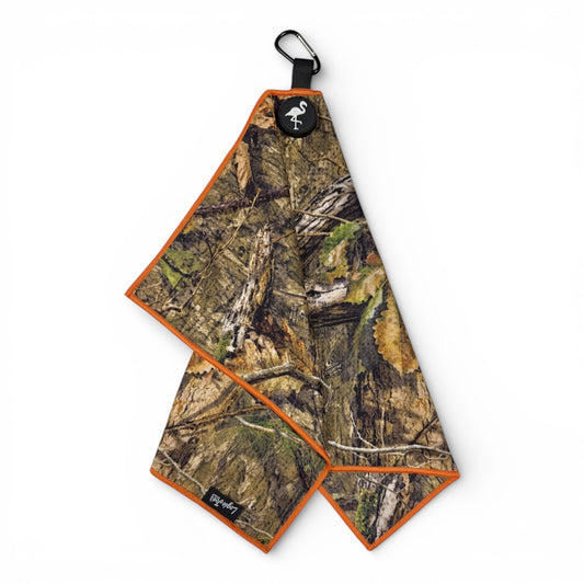 The Woodland Camo Golf Towel is a 24 x 16 in premium double-sided microfiber towel with orange trim, a carabiner clip, and heavy-duty magnetic attachment—perfect for quick, durable cleaning on the course.
