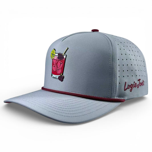 The Transfusion Golf Hat is a light gray adjustable snapback cap with a maroon edge, perforated side panels, an embroidered cocktail with lime on the front, 