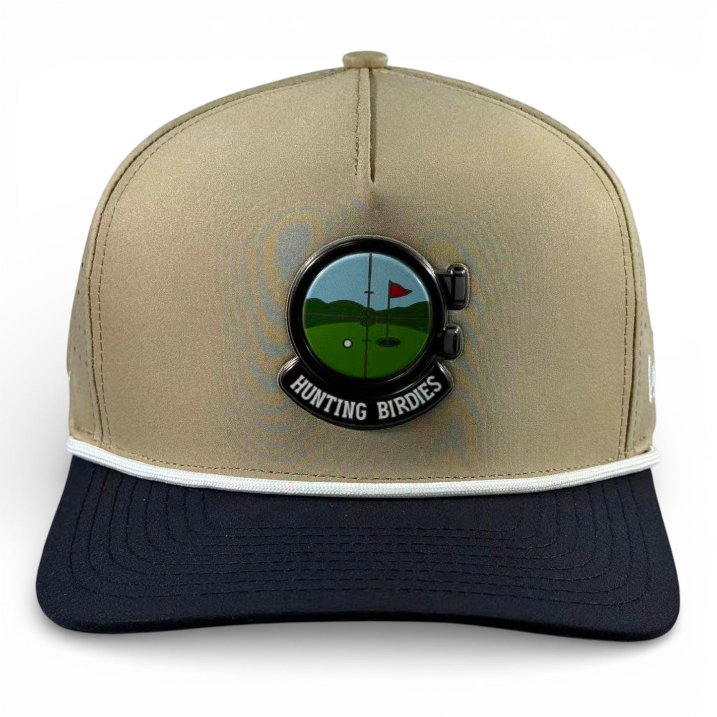 The Hunting Birdies Golf Hat is a tan and black adjustable snapback cap featuring a built-in magnetic ball marker holder with marker included, white trim above the brim, and a circular patch with a golf course scene.