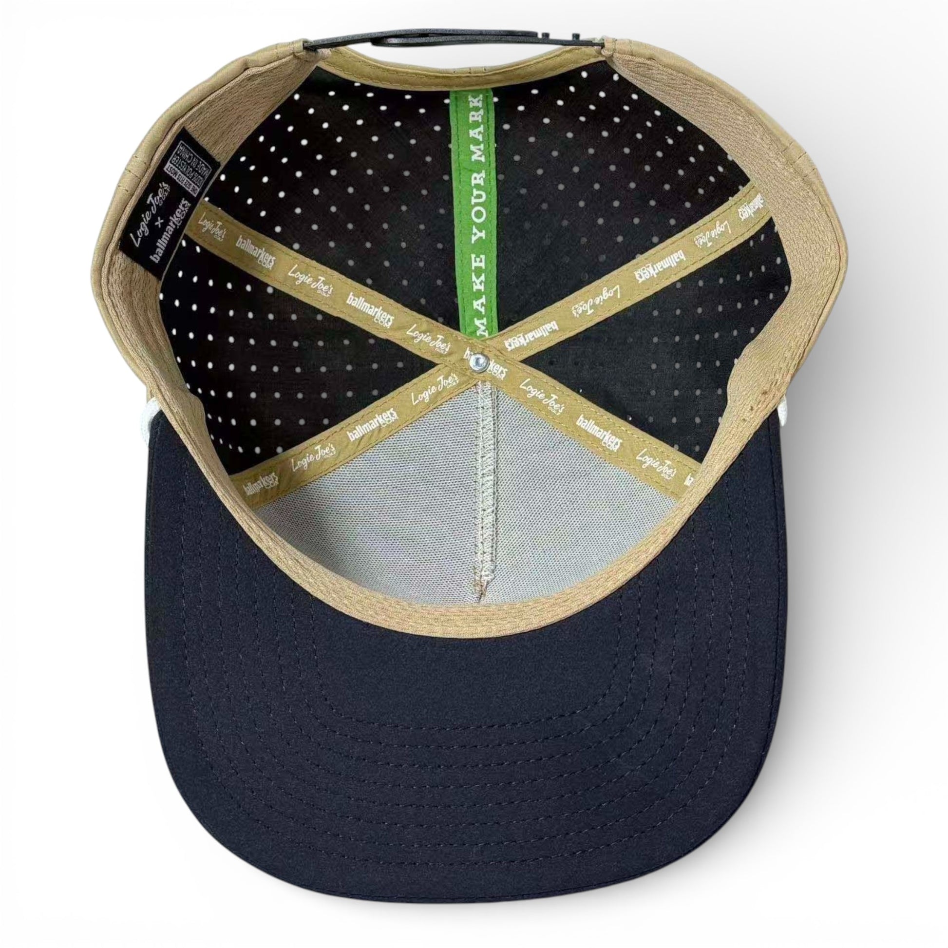 Inside view of the Hunting Birdies Golf Hat: features tan seams, polka dot black lining, a green band with "MAKE YOUR MARK," gold logo tape, navy blue underside. Snapback cap with built-in magnetic ball marker holder and adjustable fit.